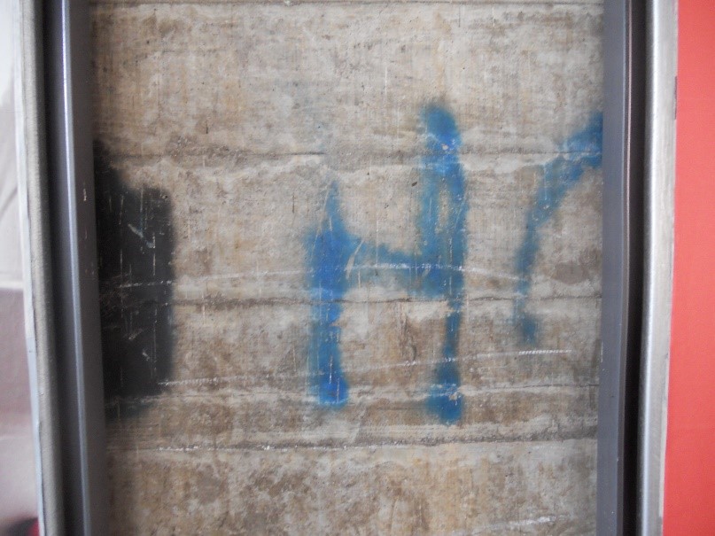 Bild 4: Unter der Eisenbahnunterführung ist eingepfercht zwischen zwei grossen Plakatwänden ein gespraytes blaues H und ein halbes O zu sehen sowie ein Rest einer schwarz gemalten Fläche (Foto: Urs Häner).